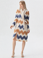 Femme blonde souriante corps entier en robe de chambre polaire longue zigzag bleu ardoise et caramel, col châle crème, ceinture crème, sandales blanches plates