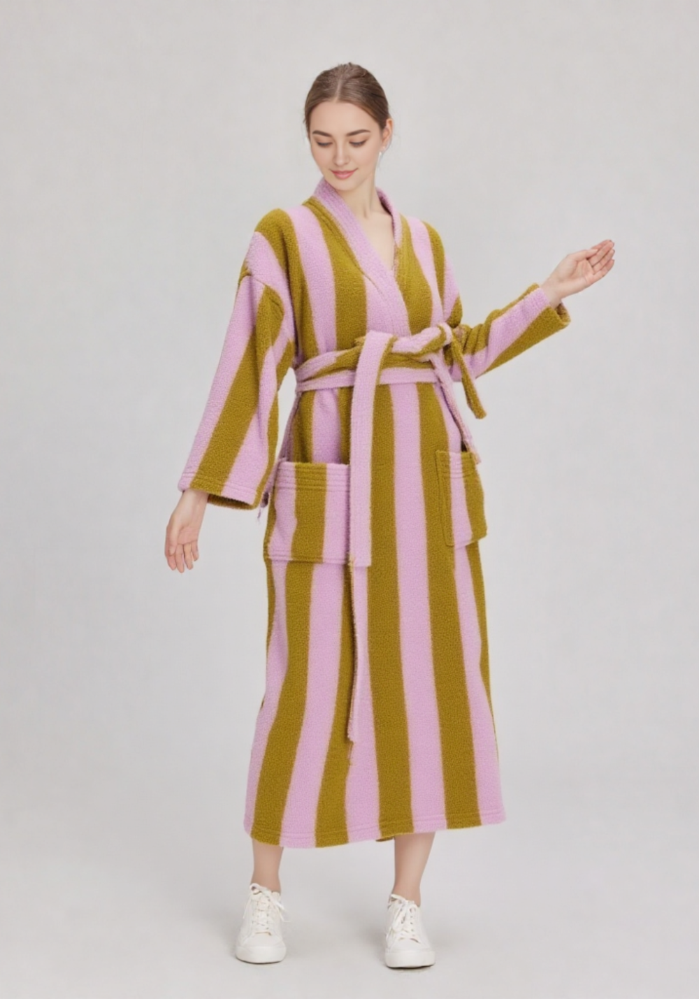 Femme de 3/4 en ensemble kimono et pantalon polaire rose et kaki à rayures, ceinture rose, baskets blanches, corps entier