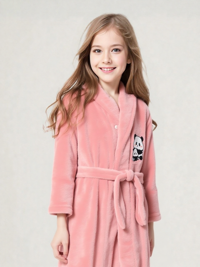 Fille souriante aux longs cheveux châtains portant une robe de chambre polaire rose corail avec appliqué panda et ceinture nouée