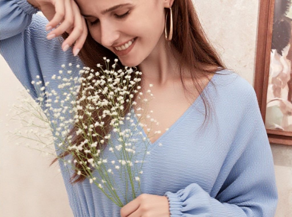 Femme souriante en robe de chambre bleu ciel avec un bouquet